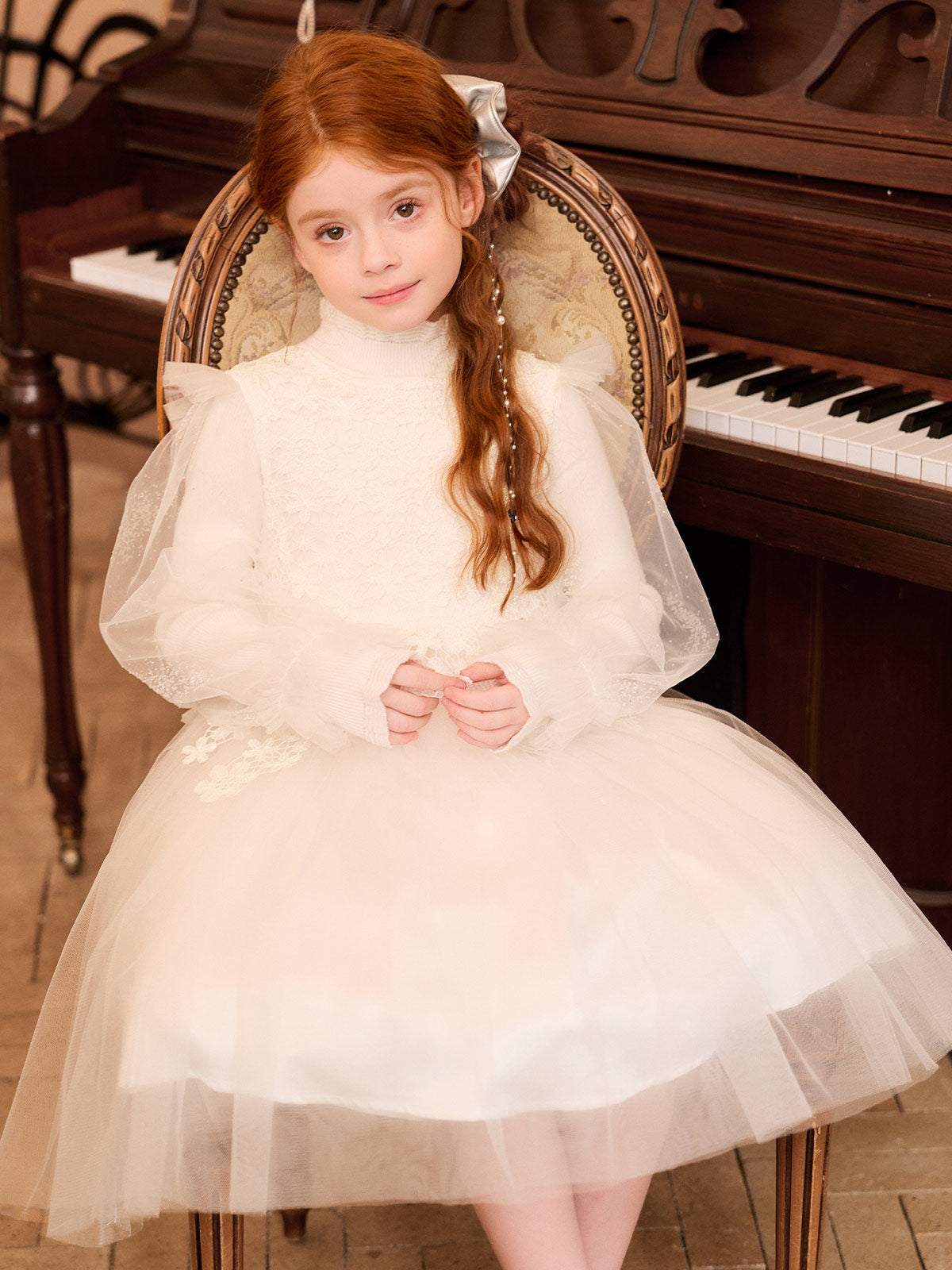 Front seated model view showing the ivory floral lace bodice and tulle skirt