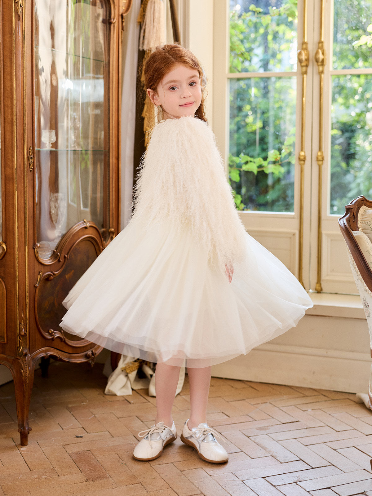 Movement view of the cream tulle dress styled with a textured outer layer