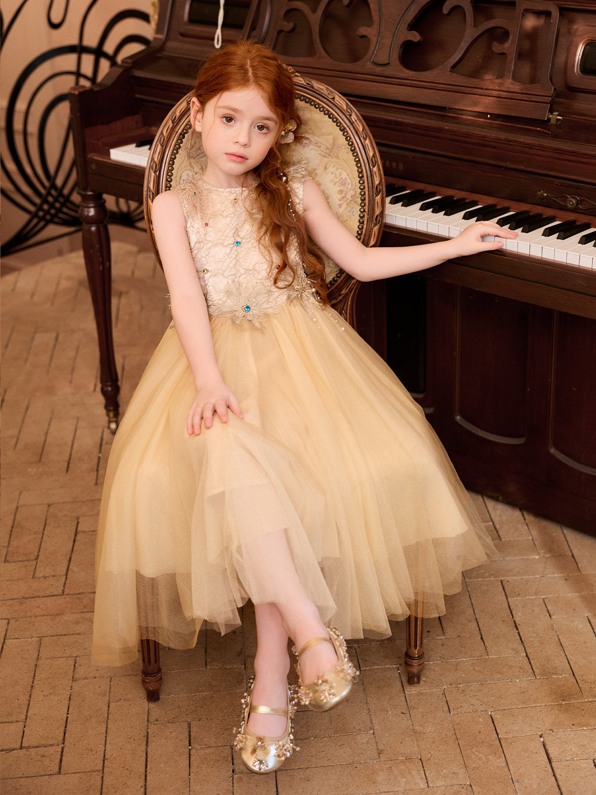 Seated model wearing the sleeveless champagne tulle dress