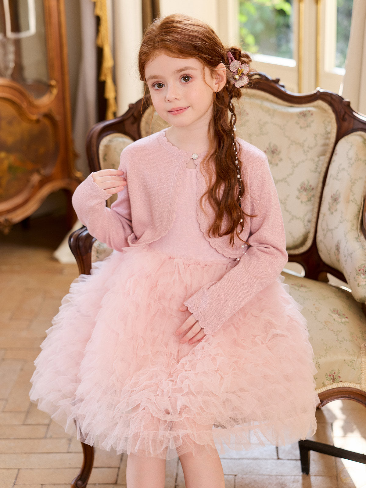 Seated model wearing the Blush Shimmer Cloud Knit Dress