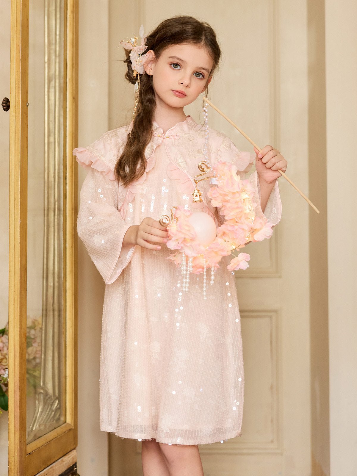 Girl wearing the Blush Sparkle Lotus Cape Dress