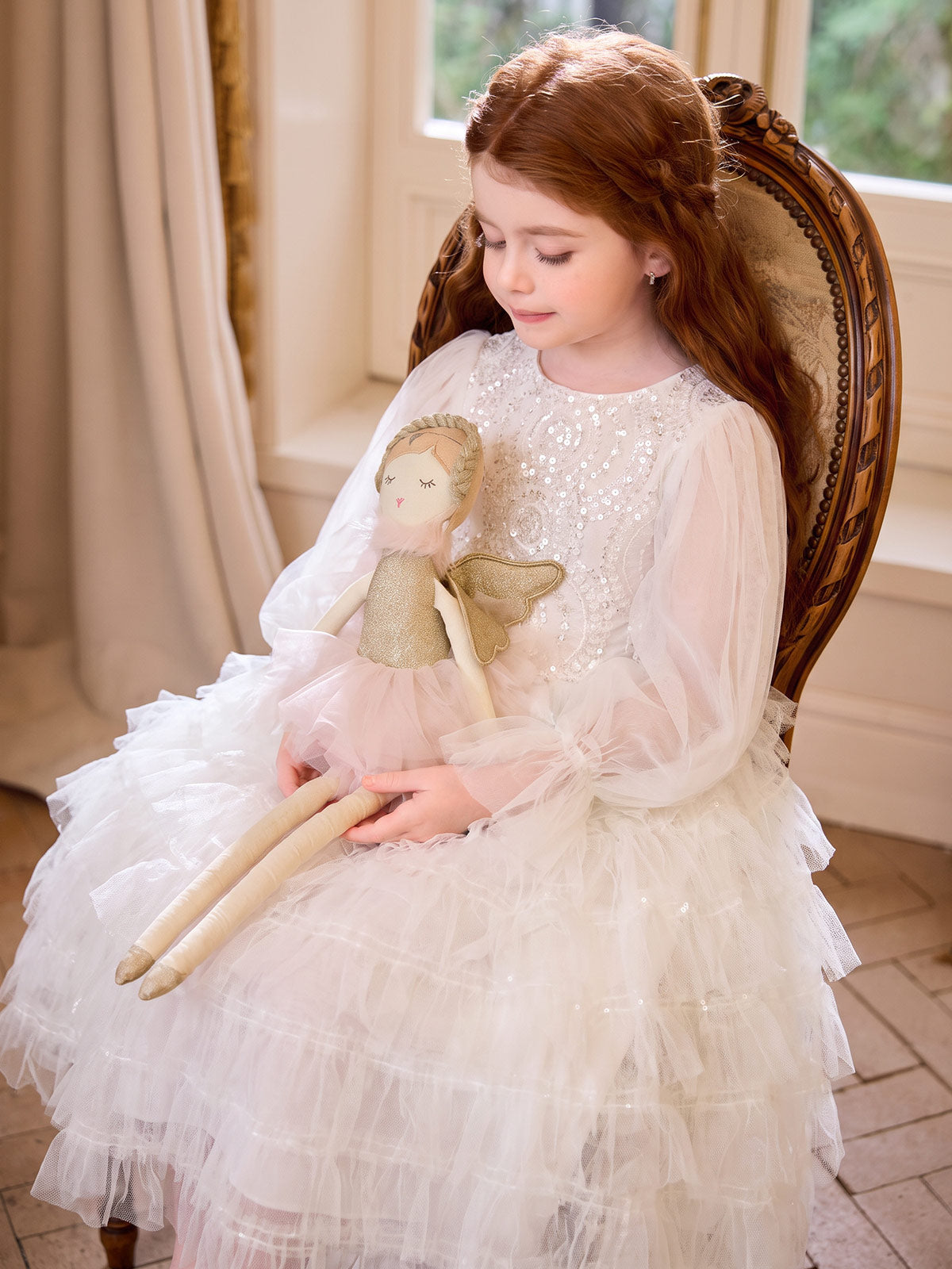Girl seated in the ivory Sparkle Tiers occasion dress