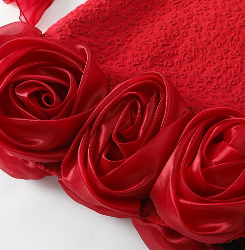Sculptural satin roses around the curved hem